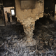 A man wearing a surgical mask walks amongst the debris of the damaged and burnt-out trauma centre on Oct. 14, 2015.